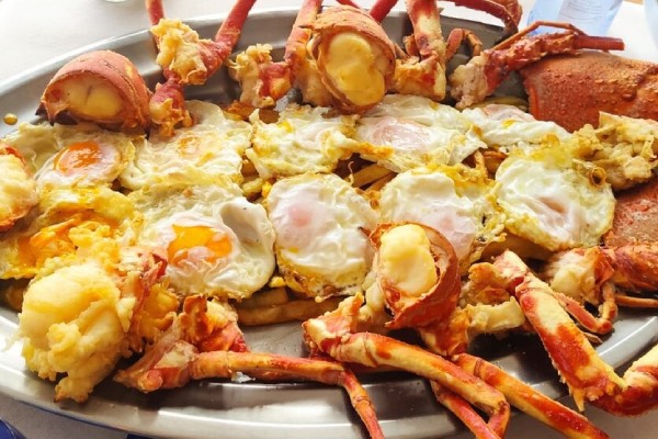 Detalle de plato de langosta con huevos fritos en restaurante el pescador fornells en Menorca